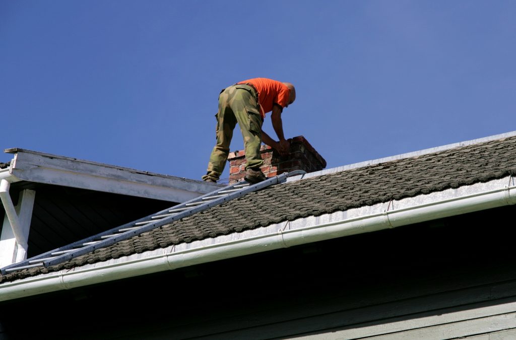 Man on the roof inspecting his chimney