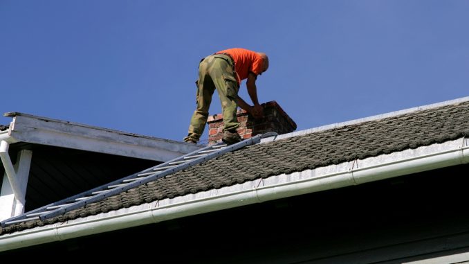 Man on the roof inspecting his chimney