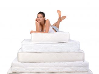 a woman lying on a stack of mattresses