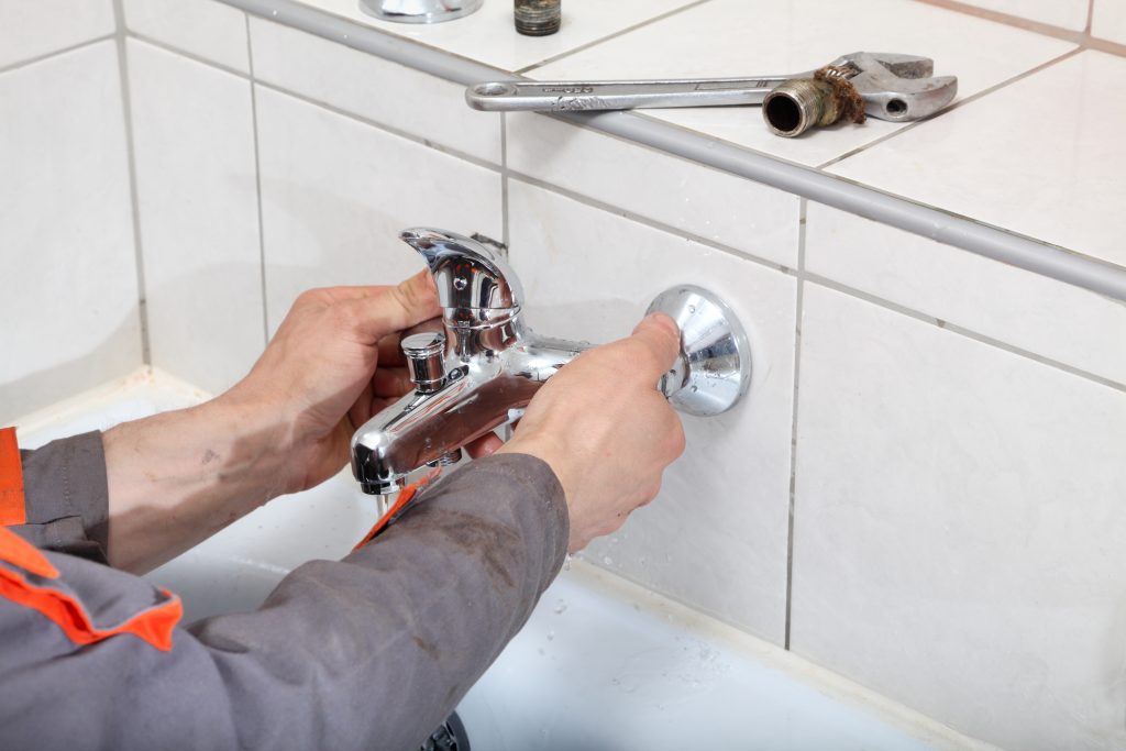 Plumber fixing water tap
