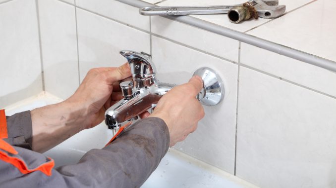 Plumber fixing water tap