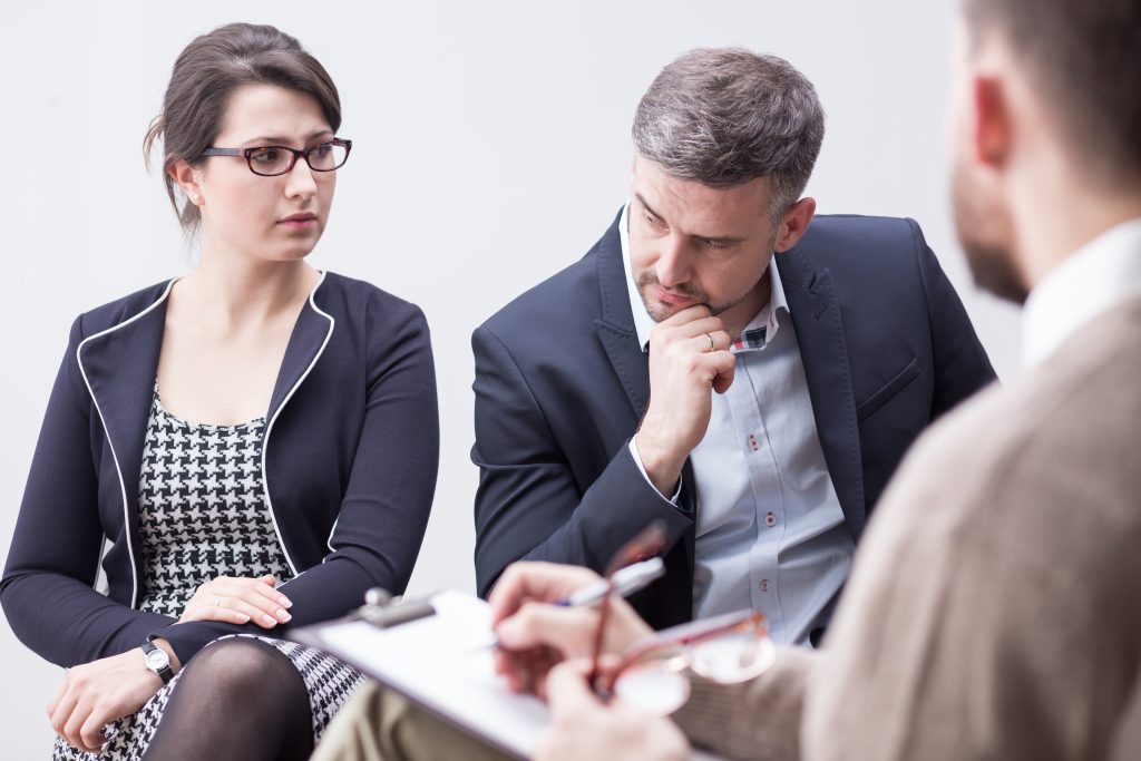 a divorce mediator listening to the grumble and fuss of a couple