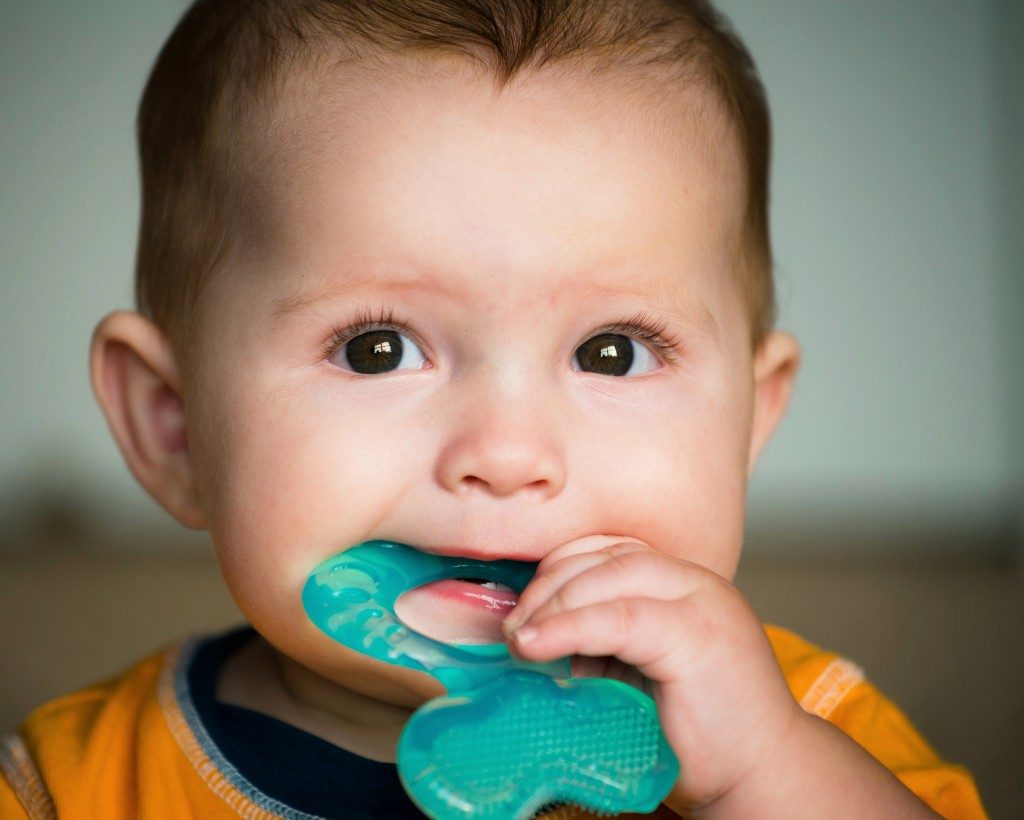 a baby chewing on a teether