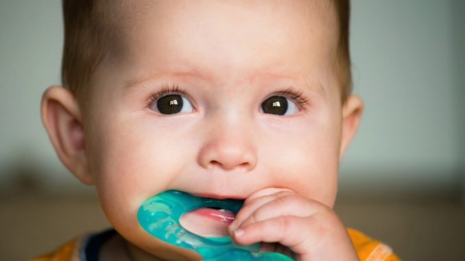 a baby chewing on a teether