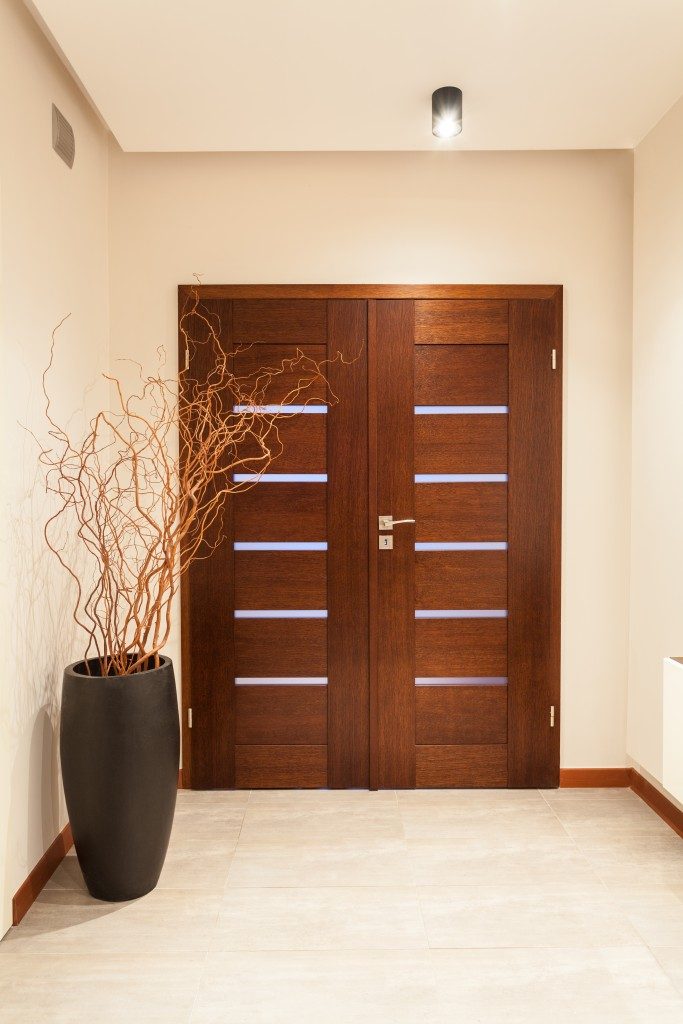 Hallway leading to closed double wooden doors.