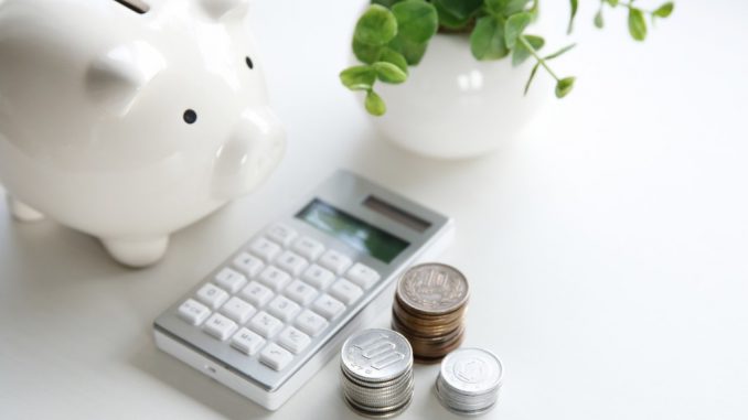 a piggy bank and an electronic calculator with coins on the side