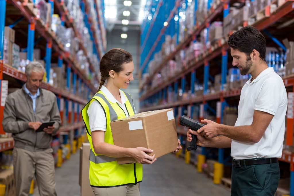 packaging warehouse with three factory workers