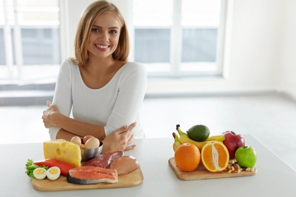 Woman with different food products in front