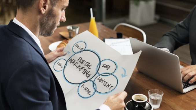 businessman holding a paper that shows different components of digital marketing