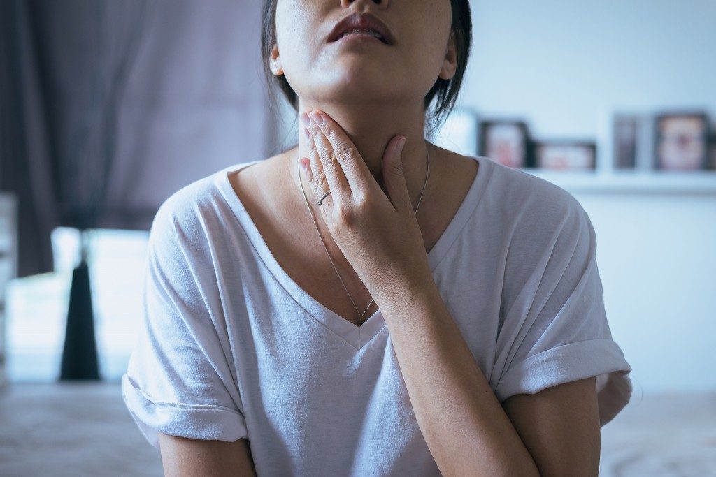 woman clutching her throat